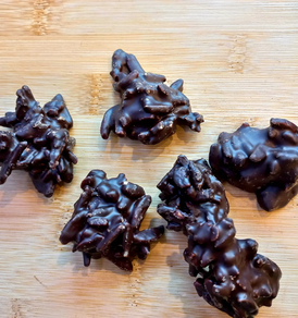 Rocas de almendras garrapiñadas bañadas en chocolate negro.  (100 gr)