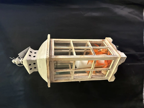 Farol con vela y adornos artificiales.